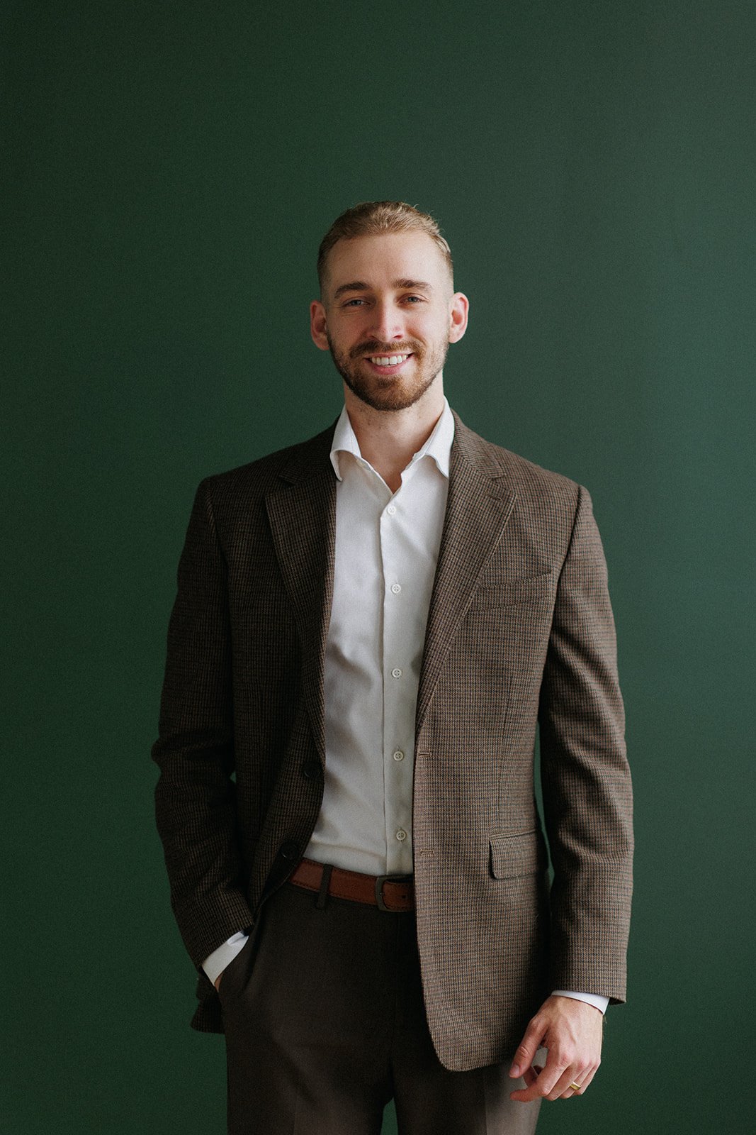 Mikael headshot standing in front of a green wall.